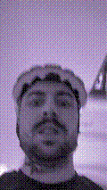 a selfie of a white person, wearing either headphones or a helmet, making an odd expression. the photo is edited to be colorized into a monochrome purple-ish color palette.